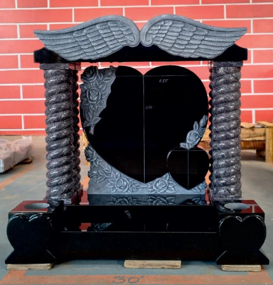 Elaborate granite memorial with sculpted angel wings and heart shapes