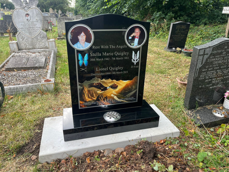 Completed black granite memorial with two portrait photographs and landscape artwork