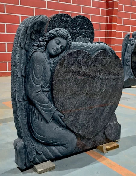 Carved stone angel leaning over a heart shaped memorial